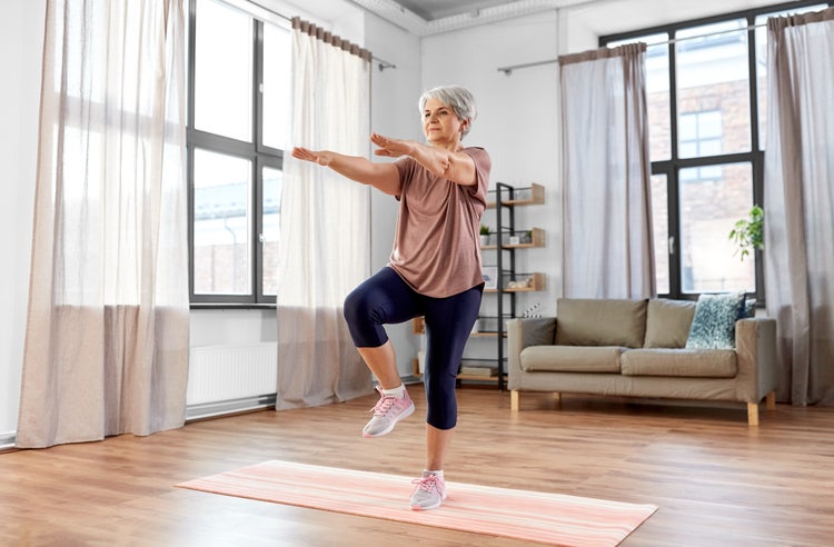 Older adult performing a wall push-up with hands against a wall